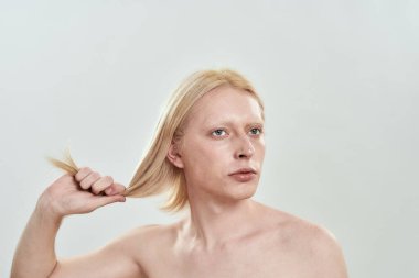 Saçlarını uzatan beyaz bir adamın portresi.