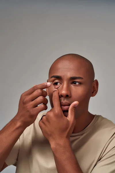 Masculino inserindo uma lente dentro de um olho — Fotografia de Stock