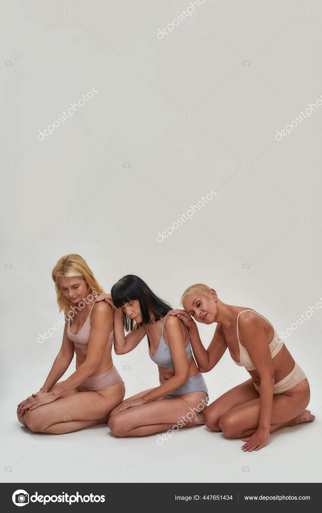 Three caucasian senior women in underwear leaning on each other while posing half naked in studio, sitting on knees together isolated over light background Stock Photo by ©LanaStock 447651434