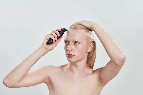 Jovem caucasiano loiro homem usando aparador de cabelo — Fotografia de Stock