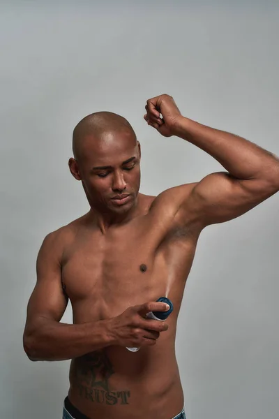 Passform afro-amerikansk person stänk spray under armen — Stockfoto