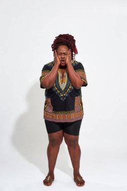 Rahatsız ve iri yarı, gözleri kapalı bir kadın.