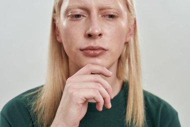 Çenesinin altında eli olan genç bir çocuğun portresi.