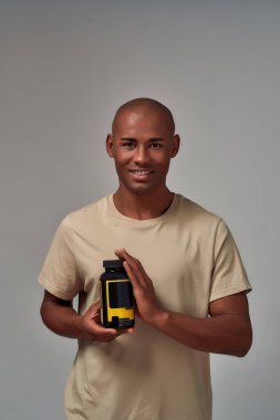 Şişedeki haplarla mutlu melez bir adam.