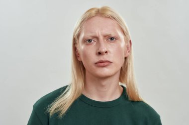 Kasvetli genç beyaz saçlı adamın portresi.