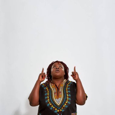 Şişman genç kadın, parmaklarını cenneti işaret ediyor.