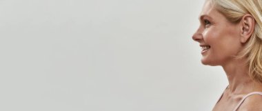 Neşeli orta yaşlı, beyaz, sarı saçlı bir kadın.