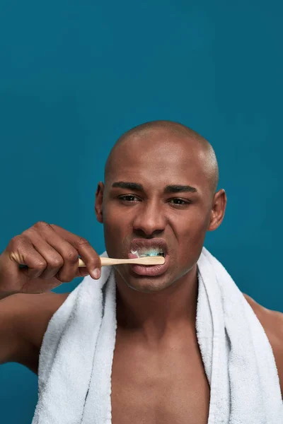 Niezadowolony dorosły mężczyzna przesuwając szczoteczkę do zębów w górę iw dół w ustach — Zdjęcie stockowe