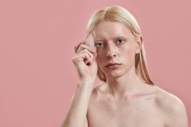 Kafkasyalı genç adam yüzüne kuvars masajı yapıyor.