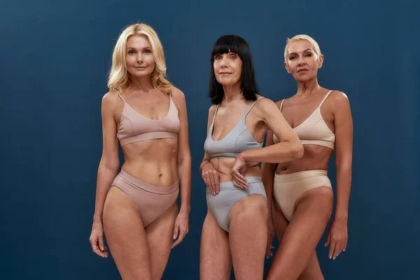 Me encanta tu cuerpo. Tres atractivas mujeres maduras caucásicas en ropa interior mirando a la cámara — Foto de Stock