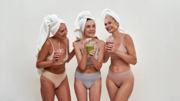 Cheerful middle aged caucasian women drinking smoothies — Stock Photo, Image