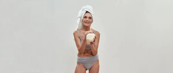 快乐的中年妇女喝着椰子做的冰沙 — 图库照片
