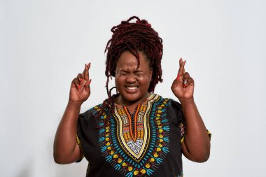 Mutlu tombul kadın parmaklarını çapraz tutuyor ve gözleri kapalı