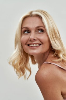 Orta yaşlı, beyaz, mutlu bir kadın.