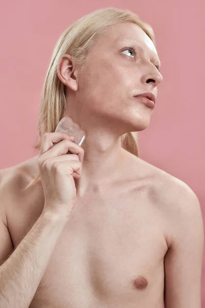 Young caucasian man massaging neck using quartz stone — Stock Photo, Image