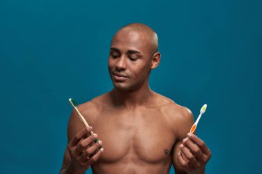 Çevre dostu diş fırçasını izleyen Afro-Amerikalı adam