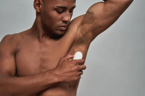 Male bringing a cosmetic alum deodorant to an armpit — Stock Photo, Image