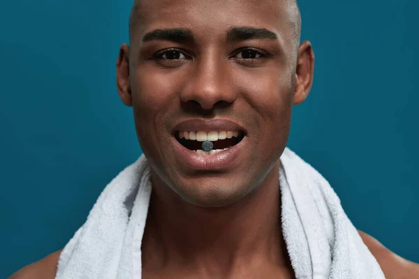 Szén tabletta fogak között egy férfi törölközővel — Stock Fotó