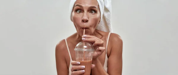 Täuschende Kaukasierin mittleren Alters trinkt Smoothie — Stockfoto