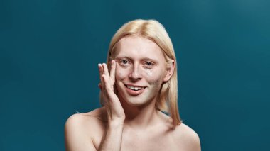 Gülümseyen beyaz bir adam deri yüzme maskesi takıyor.