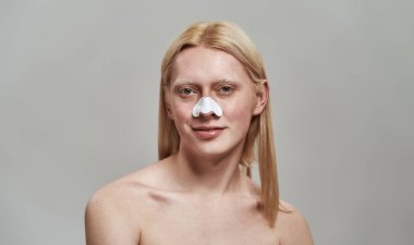 Burnunda gözenek şeritleri olan beyaz bir çocuk.