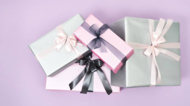 Mutlu Kadın Günleri. Mor arka planda fiyonklu renkli hediye kutularının üst görünümü