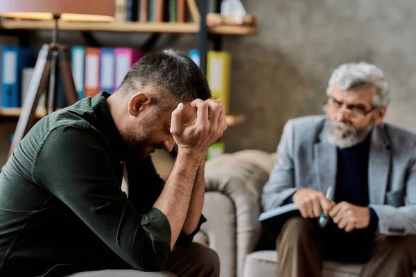Droevige man luistert naar psychotherapeut in kantoor — Stockfoto