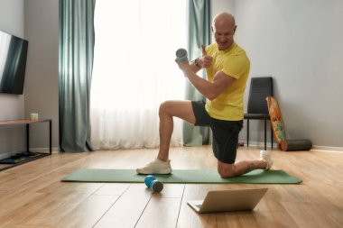 Antrenör spor minderinde tek dizinde oturuyor.