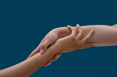 Mavi arka planda birbirini tutan iki kadının yakınlaşması.