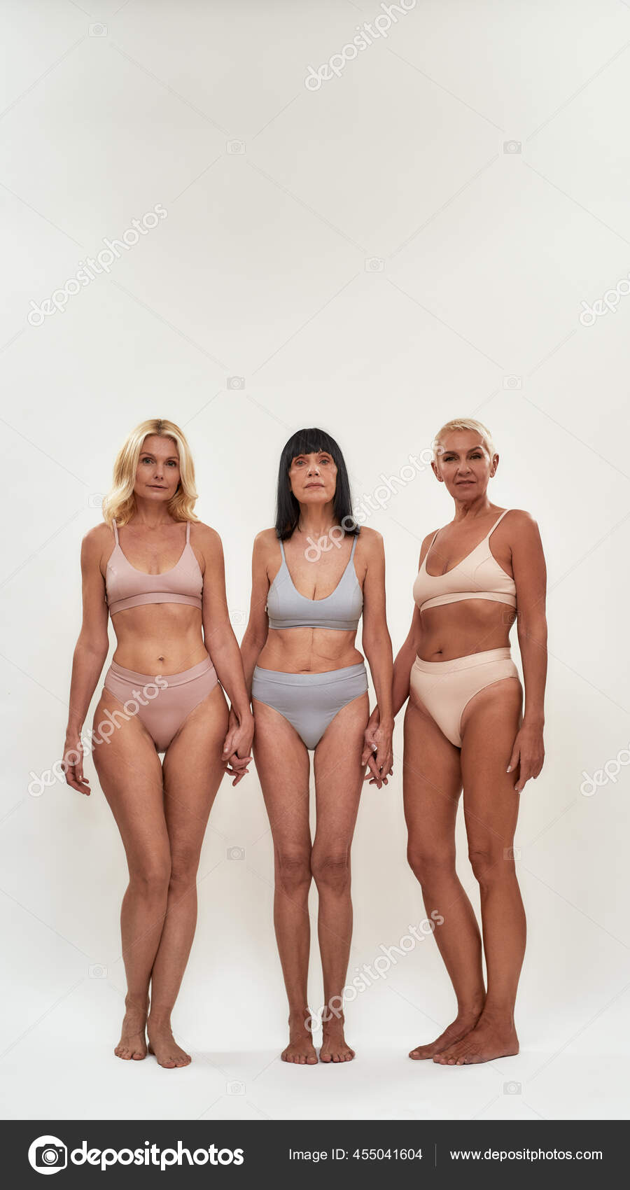 Full length shot of three happy attractive middle aged women in underwear  holding hands together and smiling at camera Stock Photo by ©LanaStock  455041604