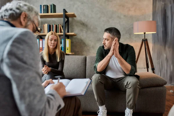 Professionele psychotherapeut die aantekeningen maakt tijdens een familiale afspraak — Stockfoto