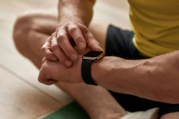 Fitness results. Cropped shot of a mature man looking at his smart watch while exercising at home