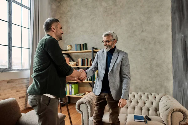 Happy young caucasian man thanking psychotherapist after meeting