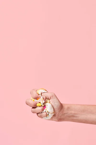 Say No to Junk Food. Say no to unhealthy food. Hand squeezing, smashing donut on pink background