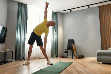 Erkek koçun antrenman yaptığı, gündüz vakti oturma odasında durduğu uzun bir çekim.