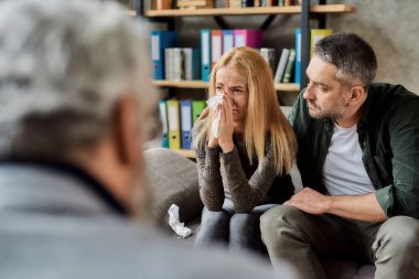 Profesyonel psikoterapistle olan randevunda ağlayan üzgün bir kadın.