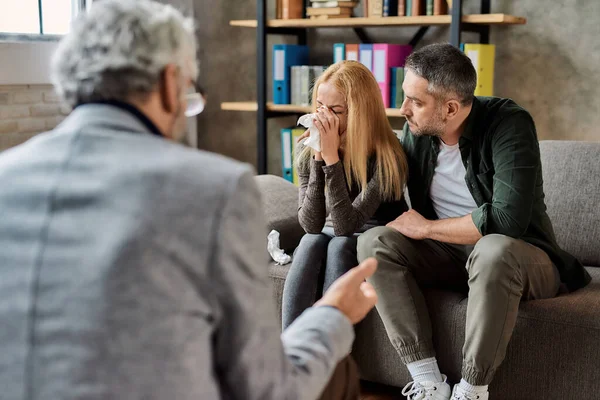 Genç beyaz kadın aile seansında ağlıyor.