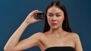 Stüdyoda elinde kremayla bir kız.