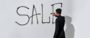 Duvara kelime satışı yapan genç bir adam.