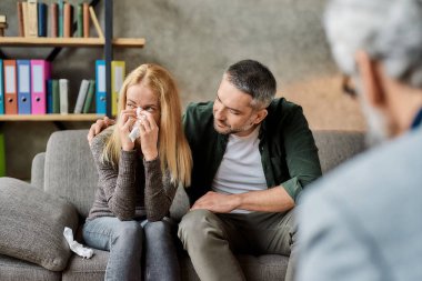 Psikoterapistle görüşürken depresyondaki kadın kocasının yanında ağlıyor.