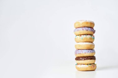 En iyi tatlı tarifi. Rengarenk donutlar kulesi. Işık arkaplanı üzerinde izole edilmiş serpinti ve jöle. Metin için kopyalama alanı.