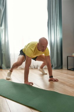 Atletik adam, spor koçu, gündüz vakti oturma odasında antrenman yapıyor.