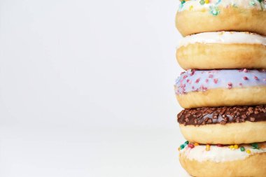 Donat Kulesi. Rengarenk donutlar ve açık arkaplanda renkli şekerlemeler.