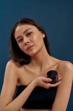 Elinde bir kavanoz kremayla genç bir kız.