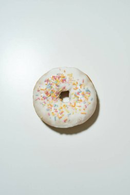 Sağlıksız tatlılar. Yakın plan çekimde taze pişmiş lezzetli donut renkli serpiştirilmiş beyaz şeker jöleli açık arkaplanda izole edilmiş.