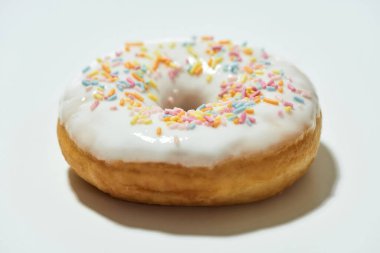 Abur cubur. Yakın plan çekimde taze pişmiş lezzetli donut renkli serpiştirilmiş beyaz şeker jöleli açık arkaplanda izole edilmiş.