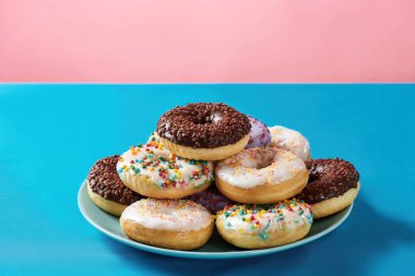 Çok lezzetli. Farklı renkli yuvarlak donutlar. Tabakta da serpiştirilmiş.