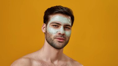 Yüzünde maske olan kahverengi saçlı genç bir adam.