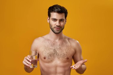 Gövdesi çıplak genç adam hapları tutuyor.