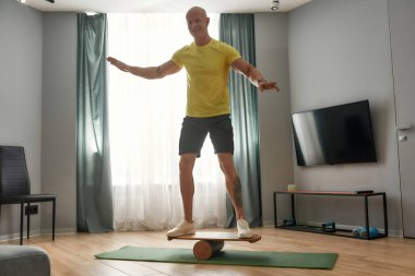 Denge panosunda gülümseyen orta yaşlı beyaz adam.